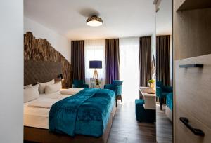 a hotel room with a bed and a desk at Arcus Hotel München Messe in Feldkirchen