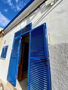 a blue shutter door on the side of a building at Sa Marineta in Porto Cristo