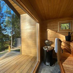 a wooden sauna with a trash can and a window at Villa Korppi in Jorvas