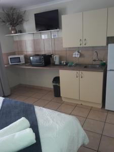 uma cozinha com armários brancos e uma bancada em Accommodation@Park1285 em Pretoria