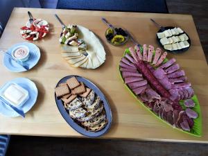 a wooden table topped with different types of food at Tattoo PENSION in Mörtschach