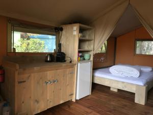 a small room with a bed and a kitchen in a tent at Budget Glamping Safaritent - Mas de Mourgues in Vauvert
