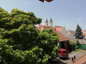 a red truck parked in a parking lot with trees at Céhmesterek apartman in Eger +31 photos