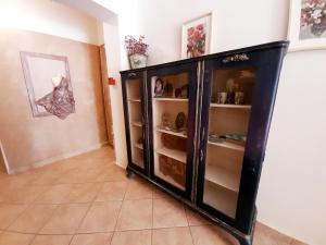 a black cabinet with shelves in a room at Anthemio in Loutraki