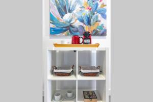 ein Regal in einer Küche mit einem Gemälde an der Wand in der Unterkunft Loft Life 3 in Arrecife