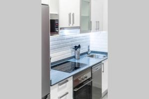 a kitchen with white cabinets and a sink at Loft Life 3 in Arrecife +10 photos