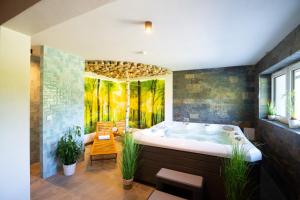 uma grande casa de banho com banheira, mesa e cadeiras em Aparthotel Pod Stokiem z sauną i jacuzzi - Dream Apart em Szczyrk