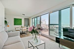 een woonkamer met een vaas met bloemen op een tafel bij Modern penthouse with stunning sea-view, sauna and 2 large terraces! in Knokke-Heist
