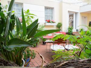 a patio with tables and chairs and plants at Hotel Zum Vetter in Finsterwalde