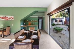 a dining room with green walls and a table and chairs at De Akker Guest House in Bloemfontein