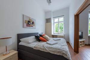 a bedroom with a bed with pillows on it at Novis Apartments Krakowskie Przedmieście in Warsaw