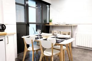 a dining room with a table and white chairs at Dolaretxe apartment by People Rentals in Bilbao