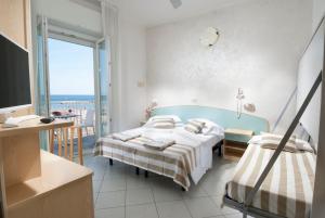 a bedroom with two beds and a view of the ocean at Strand Hotel in Gabicce Mare