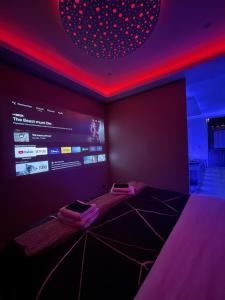 a room with a bed with a red light and a screen at Spa privatif by XELA in Auxerre