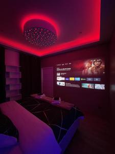 um quarto com uma iluminação vermelha e uma televisão em Spa privatif by XELA em Auxerre