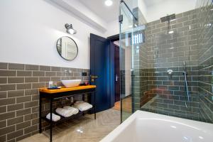 Borjomi Bridge Hotel في بورجومي: حمام مع حوض ومغسلة ودش