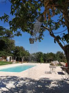 a view of a swimming pool with a table and chairs at Tenuta Colavecchio B&B in Putignano