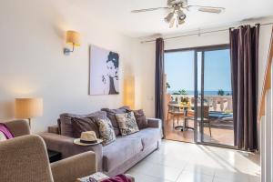 美洲海滩Tenerife South Apartments的带沙发的客厅，可欣赏海景