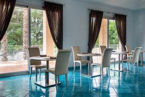 un comedor con mesas y sillas y una gran ventana en Residenza Del Mare en Sant'Isidoro