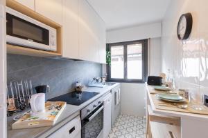 cocina blanca con fregadero y microondas en Agirre - BasKey rentals, en Lekeitio