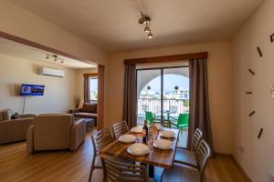 Leucolla Hill & Sea في بروتاراس: غرفة طعام مع طاولة وكراسي وغرفة معيشة