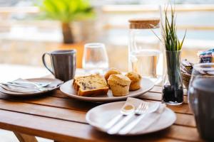 a wooden table with plates of bread and utensils at Grand View in Kamares