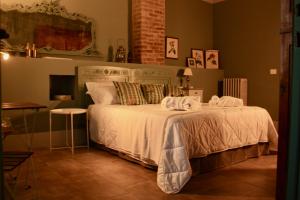 sypialnia z łóżkiem z białą pościelą i poduszkami w obiekcie Casapaletti Country House w mieście Alfiano Natta