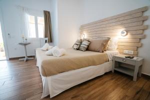 a bedroom with a large bed with a wooden headboard at Grand View in Kamares