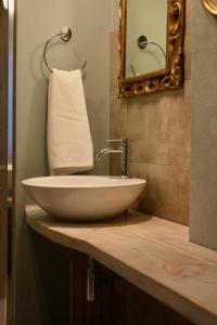 W łazience znajduje się biała umywalka i lustro. w obiekcie Casapaletti Country House w mieście Alfiano Natta