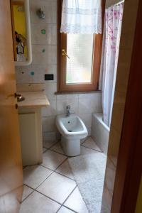 a bathroom with a toilet and a sink and a window at Casa I Girasoli in Vezzano Ligure