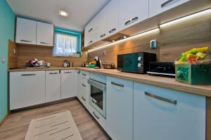 a kitchen with white cabinets and a counter top at Guest house Stefan in Balchik