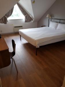 a bedroom with a large bed and a wooden floor at 247Hotel.com in Oldham