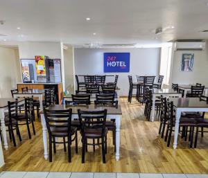 un ristorante con tavoli e sedie e un cartello che legge Air Hotel di 247Hotel.com a Oldham