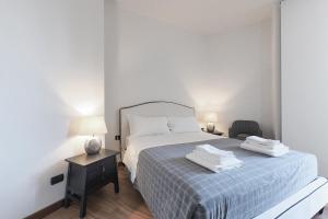 a bedroom with a bed with a blue blanket and a chair at Duomo Luxury Apartment IV in Milan