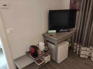 a television on a table in a room at Rossetto e cocciolato - Stanza indipendente con bagno privato a Pesaro in Pesaro