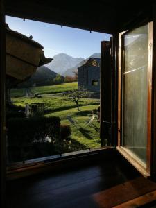 una finestra aperta con vista sulle montagne di Casa Nossur a La Salle