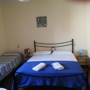 1 dormitorio con 1 cama azul y 2 toallas en Ca Angiola, en Moglia