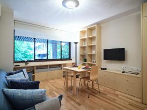 ein Wohnzimmer mit einem Tisch und einem TV in der Unterkunft My City Home - Incredible apartment at Salamanca in Madrid