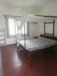 a bedroom with a bed with a canopy at Chiky Villa in Watamu