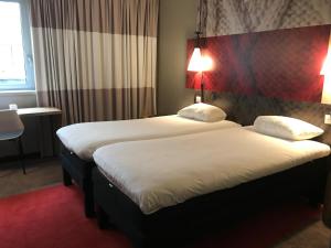 2 camas en una habitación de hotel con sábanas blancas en ibis Rouen Centre Champ de Mars, en Rouen