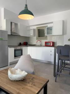 a kitchen with white cabinets and a wooden table at Chrisantakis appartments in Drios