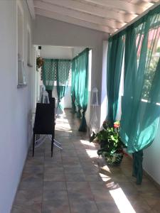 un corridoio con tende verdi e piante in una stanza di IsadeMar a Santa Teresa di Gallura