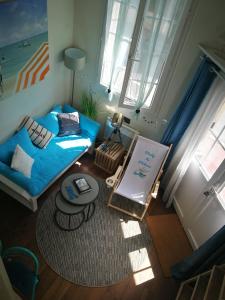 een woonkamer met een blauwe bank en een tafel bij Study du pêcheur in Trouville-sur-Mer