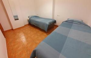 um quarto com 2 camas e piso em madeira em Apartment Armenka Duquesa em Torremolinos