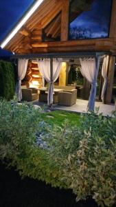 サパレヴァ・バニャにあるAlpina Luxury Chaletsの屋外パティオ(白いカーテン、ソファ付)