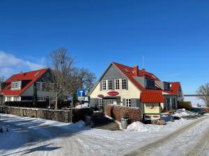 ein Haus mit roten Dächern auf einer verschneiten Straße in der Unterkunft Fleesensee Resort & Spa in Göhren-Lebbin