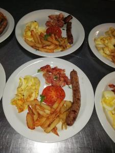 a table with plates of food with sausage and french fries at ThabaNkwe Bushveld Inn in Thabazimbi