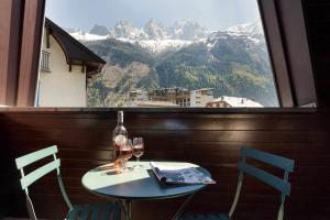 d'une table avec deux chaises et d'une fenêtre avec vue. dans l'établissement Apartment Lachenal - Alpes Travel - Alpes Travel - Central Chamonix - sleeps 4, à Chamonix-Mont-Blanc