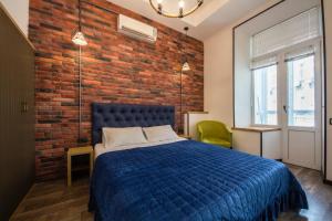 a bedroom with a blue bed and a brick wall at Central Apartments Maidan Area in Kyiv