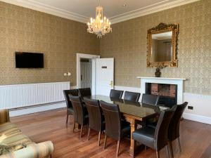 a dining room with a table and chairs and a fireplace at Colwick Hall Hotel in Nottingham